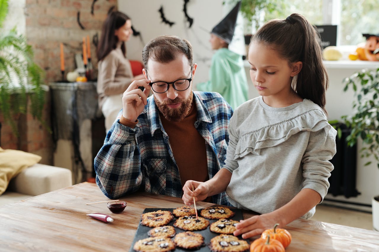 Father and daughter decorating cookies together at home